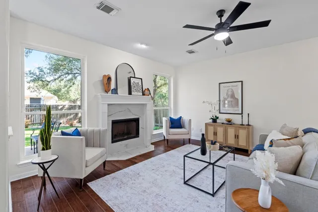 a living room with furniture a fireplace and a large window