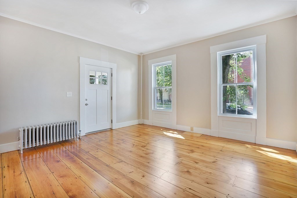 123 Springfield Street Chicopee, MA 01013 - Photo 11 of 42 a view of an empty room with wooden floor and a window