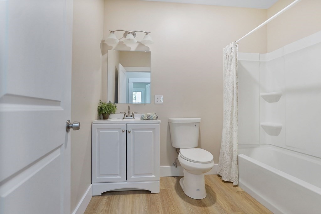 123 Springfield Street Chicopee, MA 01013 - Photo 19 of 42 a bathroom with a granite countertop toilet a sink and a bathtub
