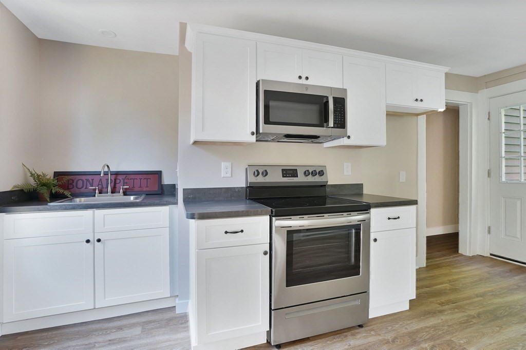 123 Springfield Street Chicopee, MA 01013 - Photo 32 of 42 a kitchen with white cabinets and stainless steel appliances