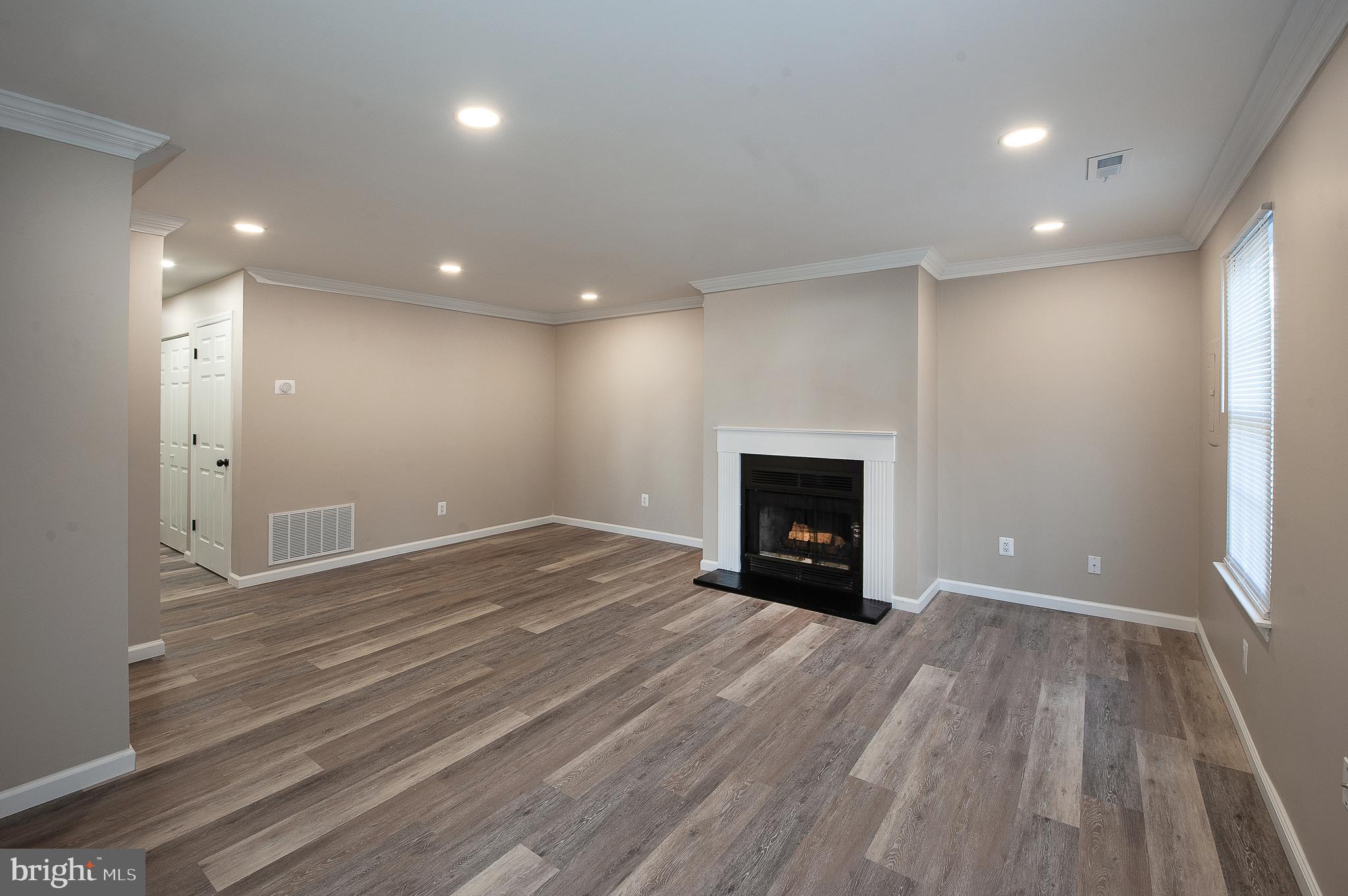 1010 Huntingdon Mews Clementon, NJ 08021 - Photo 3 of 19 an empty room with wooden floor and fireplace