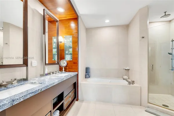 a bathroom with a granite countertop tub sink and mirror