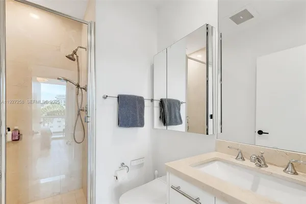 a bathroom with a granite countertop sink toilet and shower