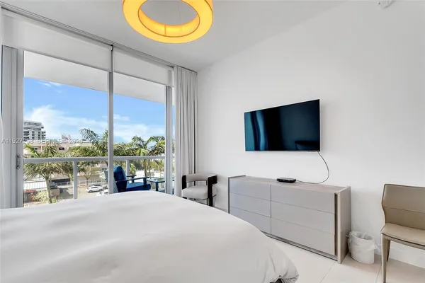 a bedroom with a bed and large window
