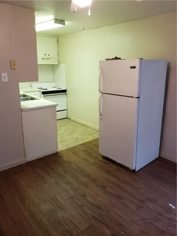 a view of kitchen with wooden floor and electronic appliances