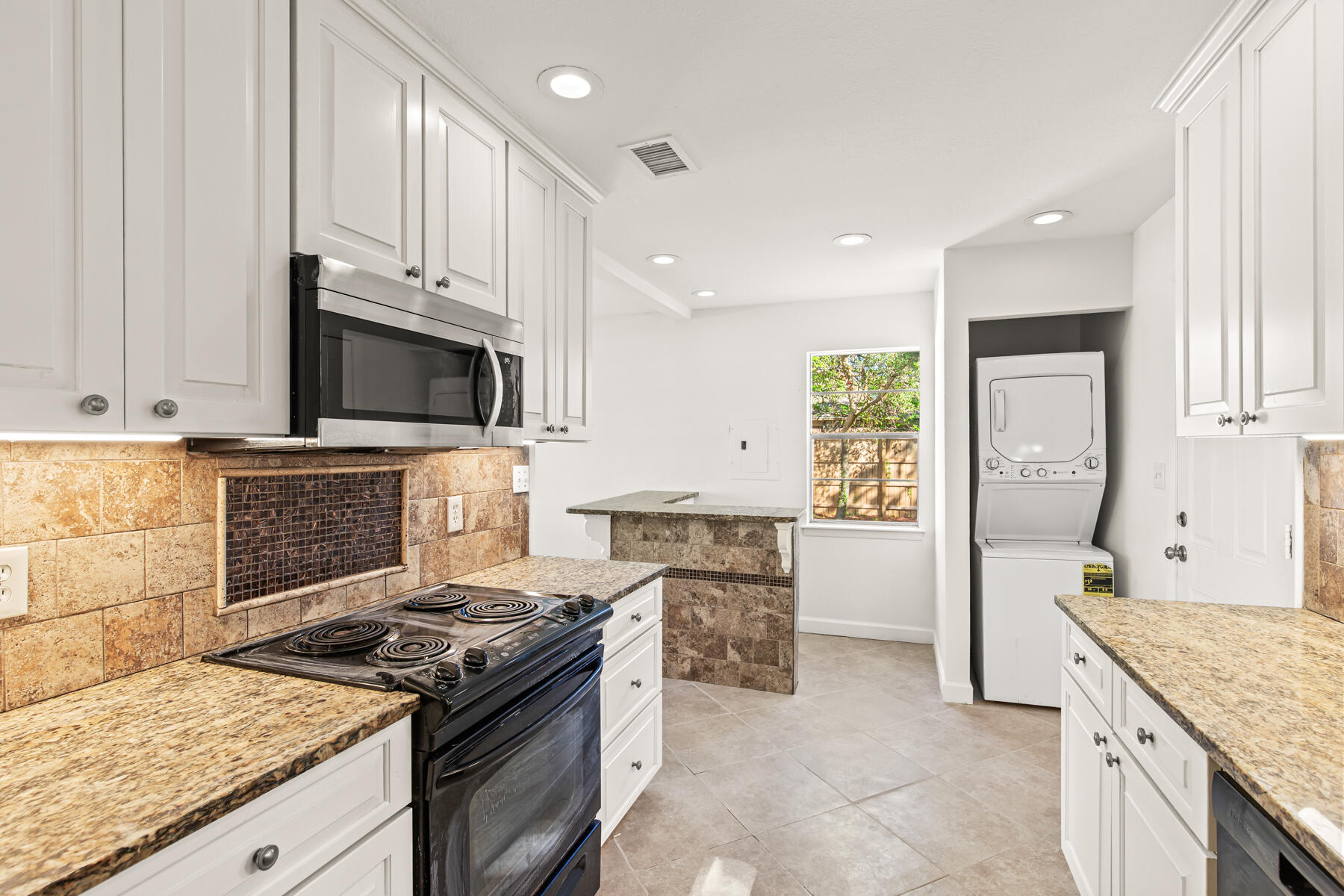 612 Beach Drive Destin, FL 32541 - Photo 11 of 34 a kitchen with granite countertop a sink stove and cabinets