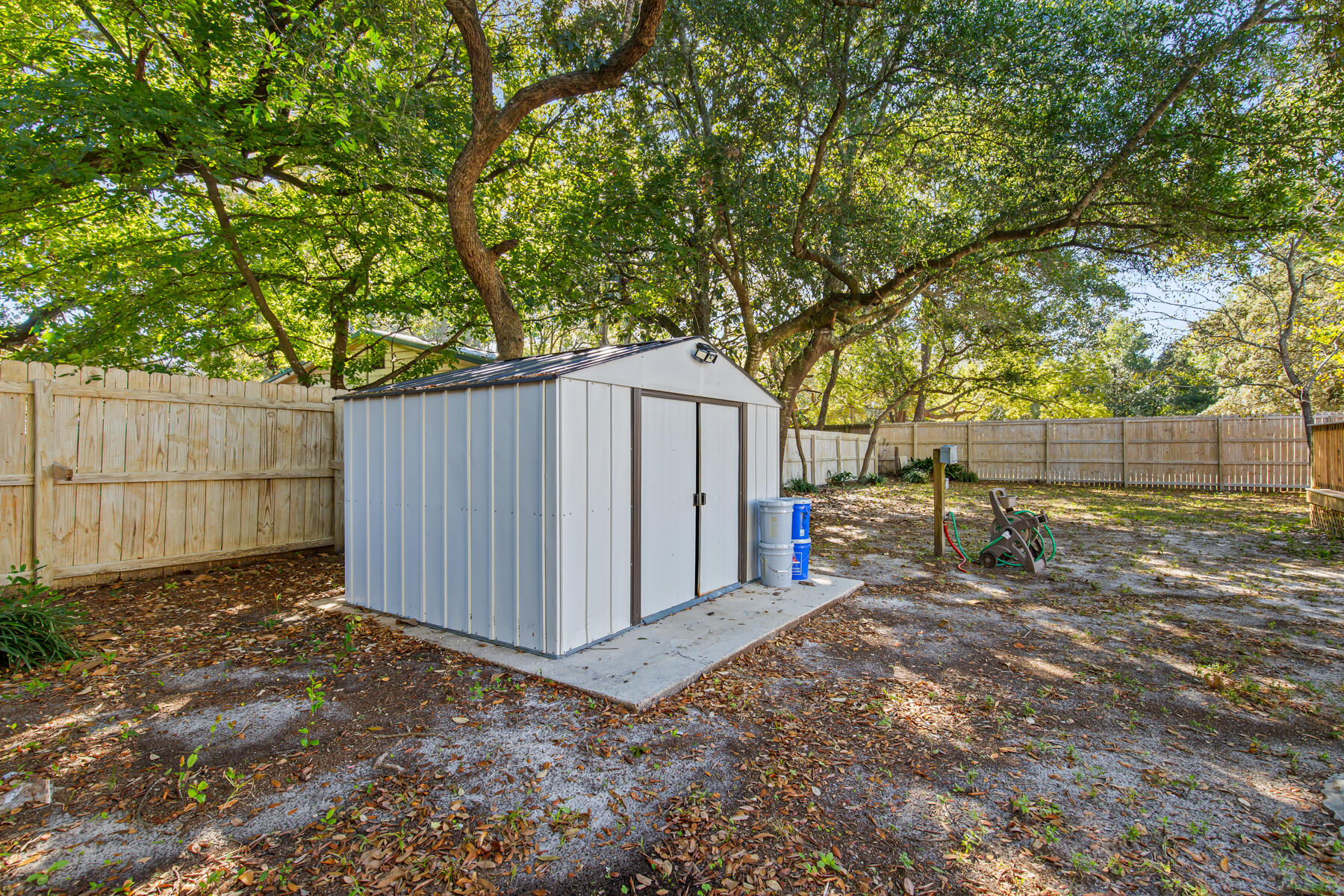 612 Beach Drive Destin, FL 32541 - Photo 23 of 34 a backyard of a house with a small barn and wooden fence