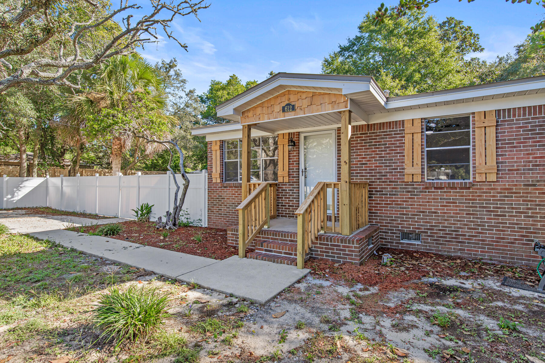 612 Beach Drive Destin, FL 32541 - Photo 4 of 34 a front view of a house with garden