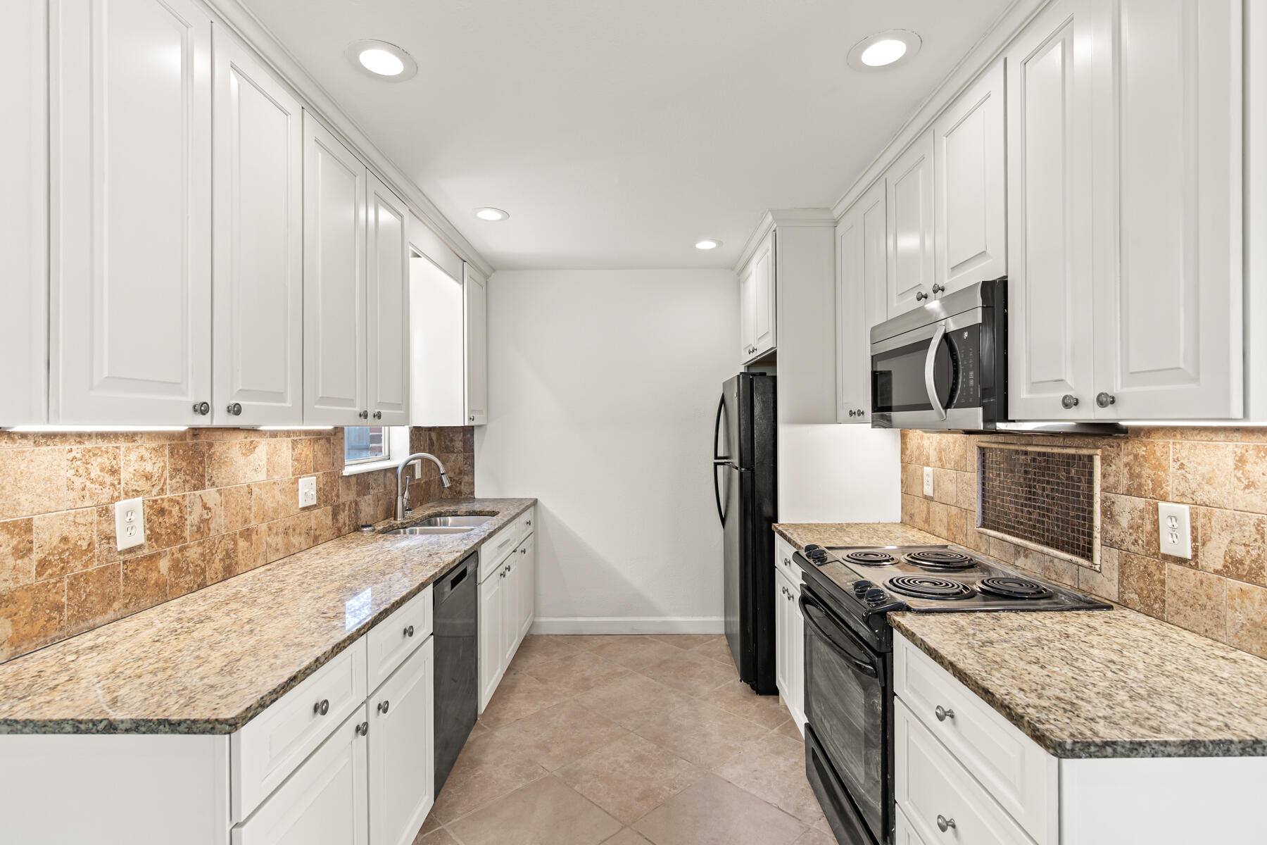 612 Beach Drive Destin, FL 32541 - Photo 9 of 34 a kitchen with granite countertop stainless steel appliances and white cabinets