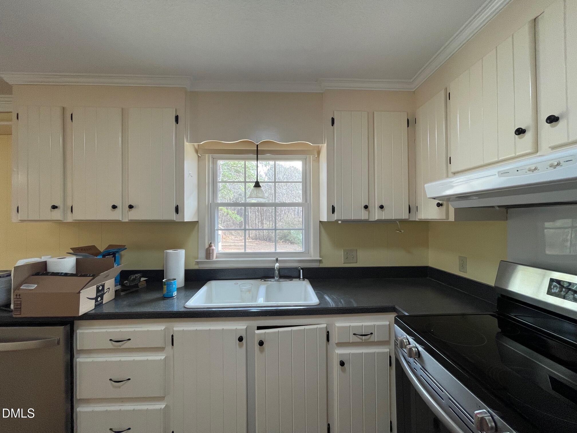 280 Montague Road Angier, NC 27501 - Photo 26 of 28 a kitchen with granite countertop white cabinets and black appliances