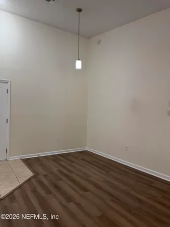 a view of a room with wooden floor and white walls