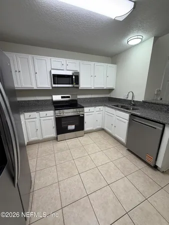a kitchen with stainless steel appliances granite countertop a sink and a stove top oven