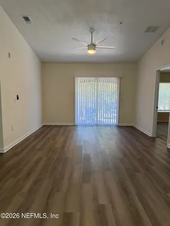 an empty room with wooden floor and chandelier