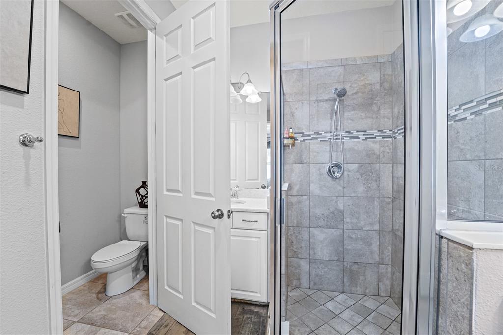 8903 Arabella Lane Seminole, FL 33777 - Photo 15 of 47 a bathroom with a granite countertop shower a toilet and a sink