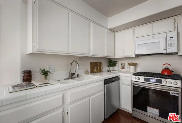 a kitchen with stainless steel appliances granite countertop a sink and a stove