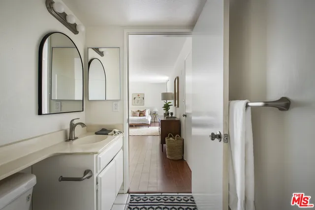 a bathroom with a sink a toilet and a mirror