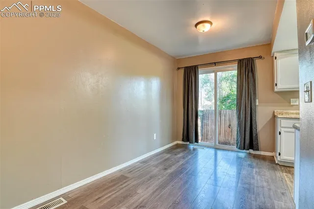 an empty room with wooden floor and a window