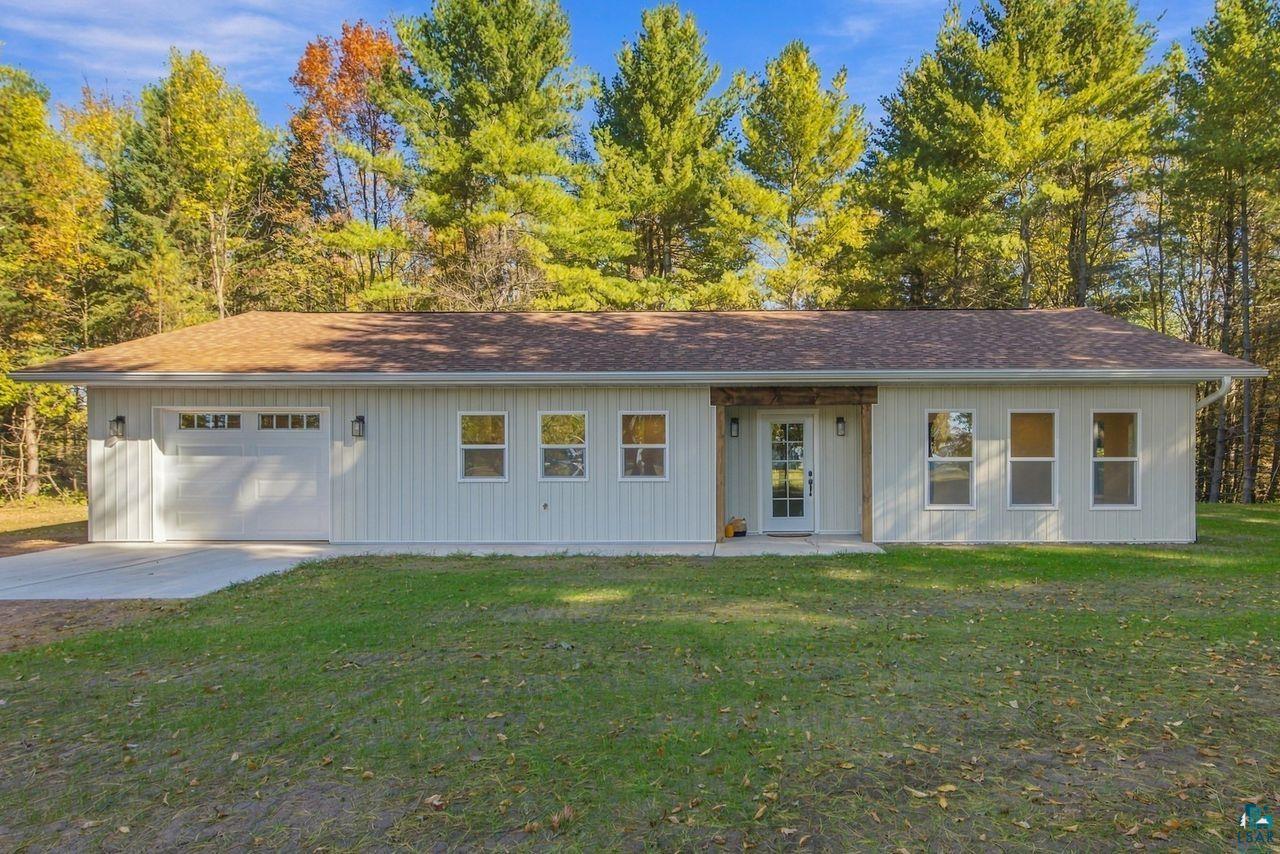 65352 Adler Road Marengo, WI 54855 - Photo 1 of 24 Single-story residence featuring light-colored vertical siding, an attached two-car garage, and a covered entry with wood-finish columns