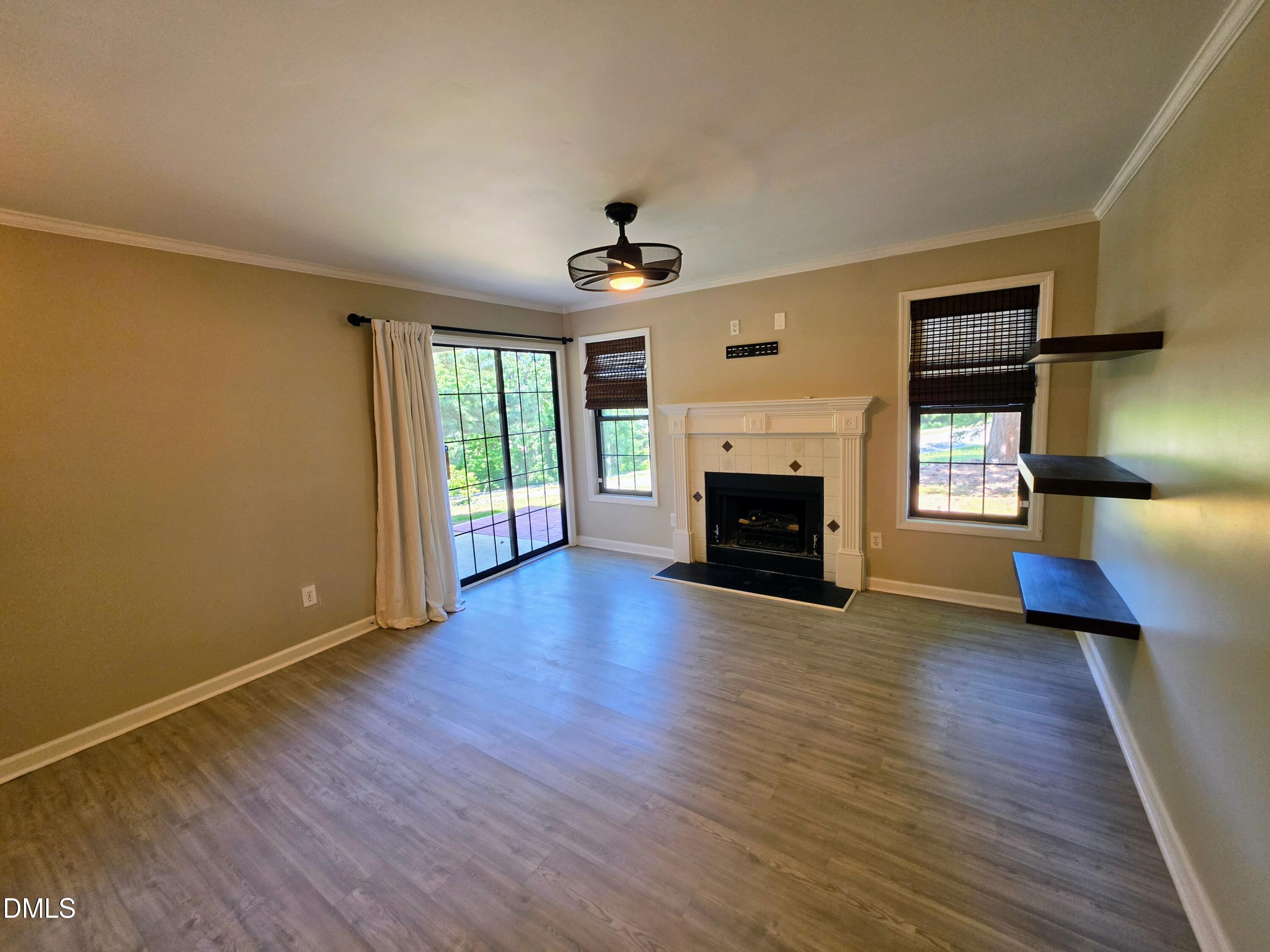 3803 Chimney Ridge Place, Unit 4 Durham, NC 27713 - Photo 4 of 16 an empty room with fireplace wooden floor and windows