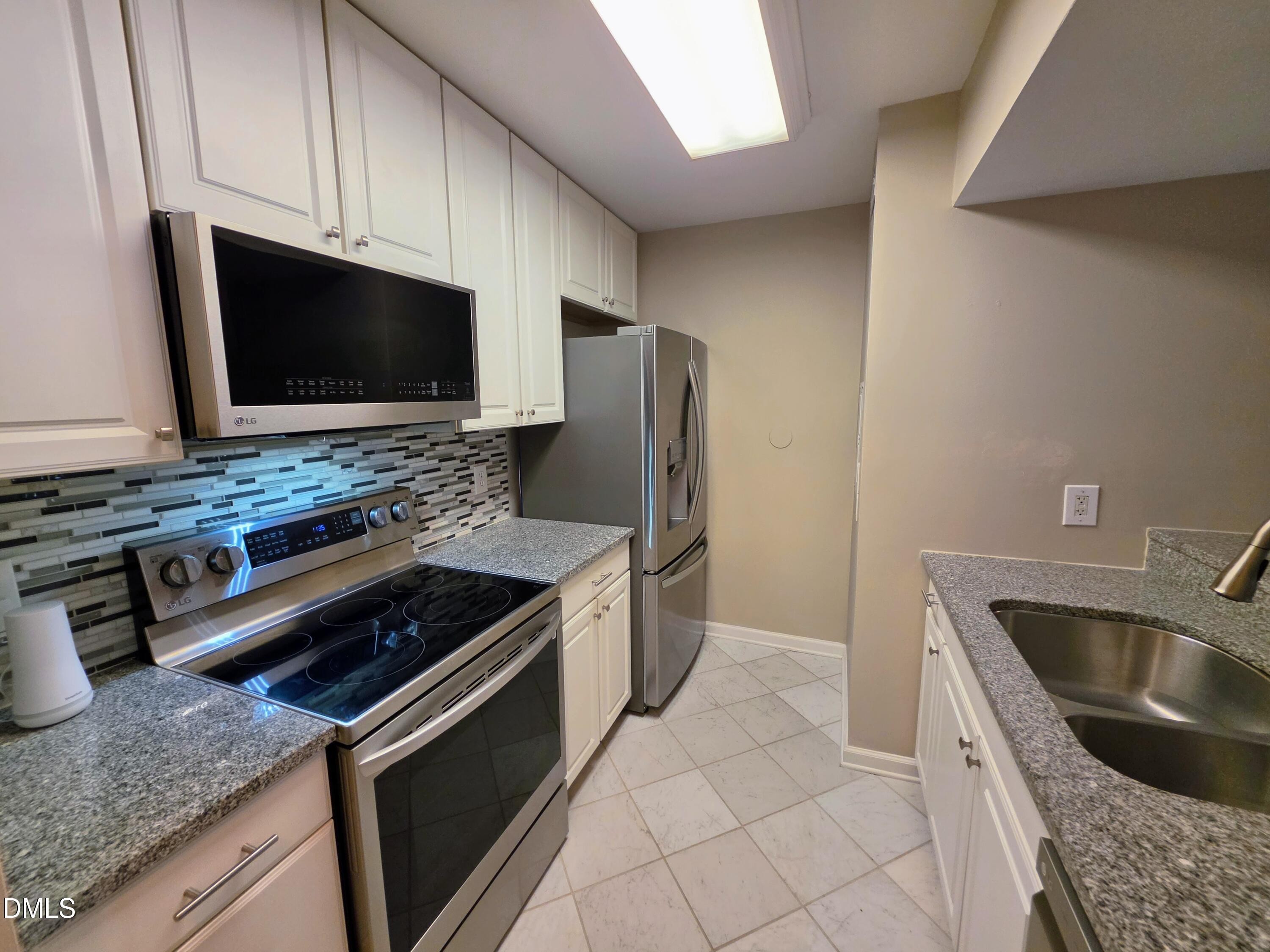 3803 Chimney Ridge Place, Unit 4 Durham, NC 27713 - Photo 6 of 16 a kitchen with granite countertop a sink and steel appliances