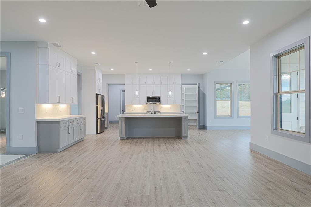 1341 Wheeler Creek Road Maysville, GA 30558 - Photo 18 of 65 a large white kitchen with a white countertops a sink and a large window