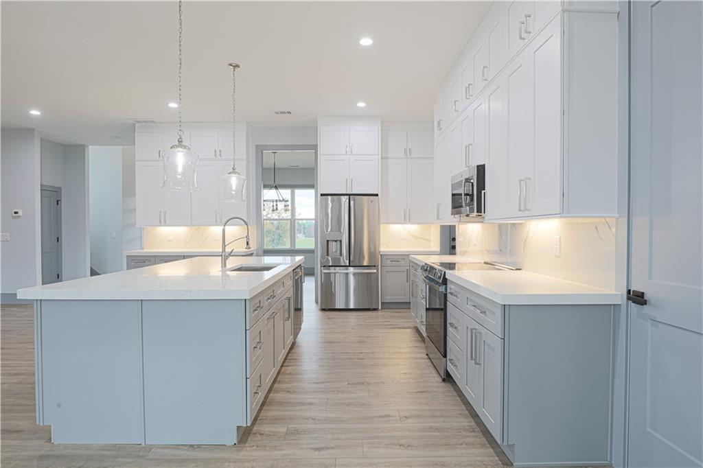 1341 Wheeler Creek Road Maysville, GA 30558 - Photo 21 of 65 a large kitchen with granite countertop a large counter top a sink stainless steel appliances and cabinets
