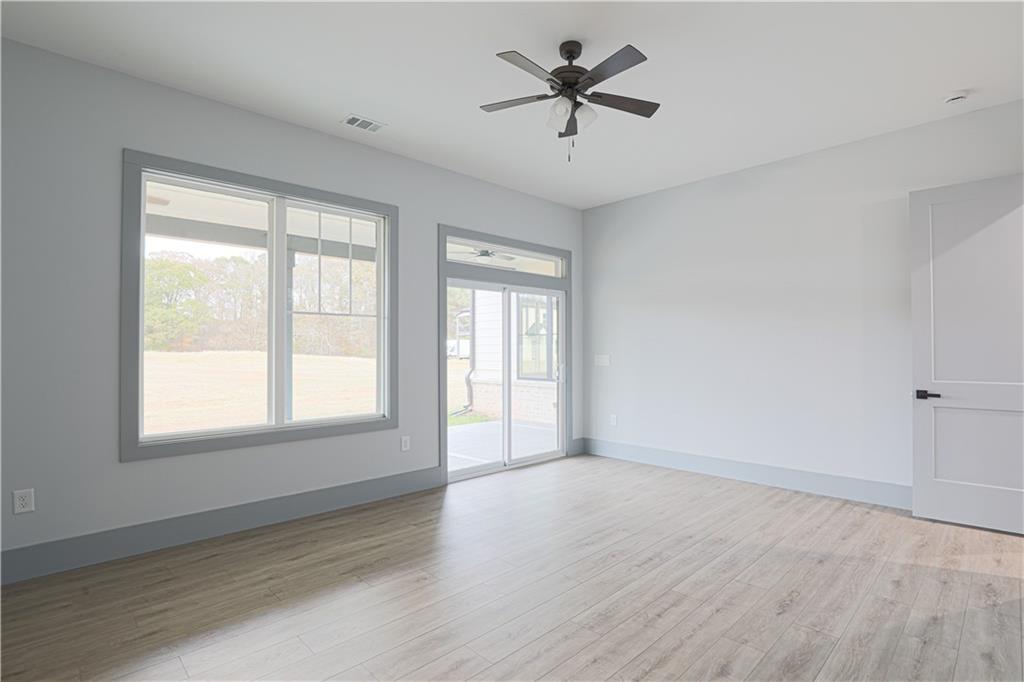 1341 Wheeler Creek Road Maysville, GA 30558 - Photo 34 of 65 a view of empty room with wooden floor and fan