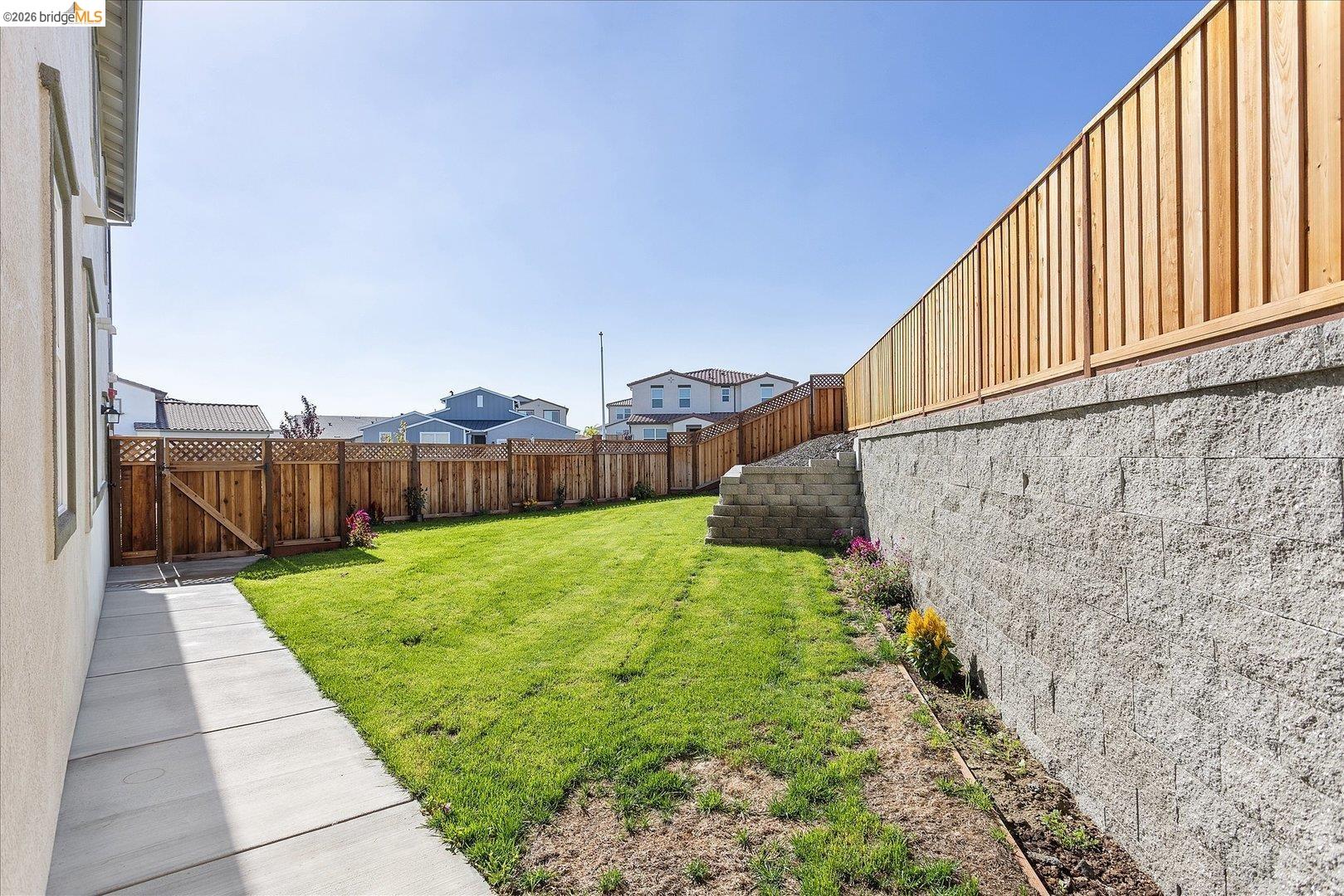 5601 Ridgepoint Way Antioch, CA 94531 - Photo 46 of 59 Expansive backyard featuring a concrete retaining wall, wood fencing, and a manicured lawn