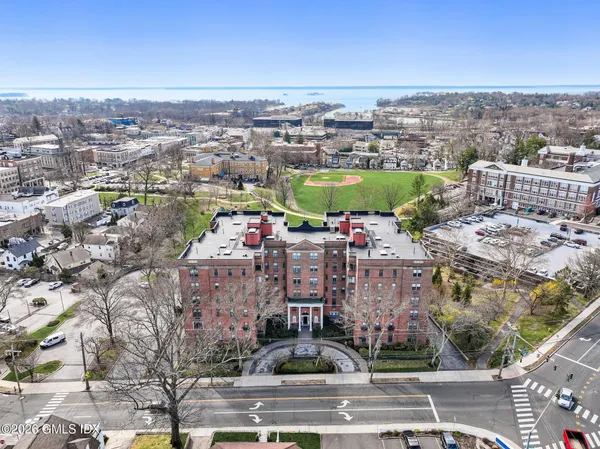an aerial view of a city with lots of residential buildings ocean and mountain view in back