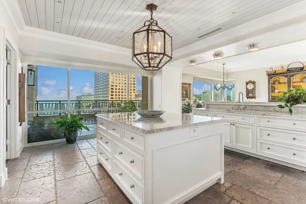 a kitchen with white cabinets and chandelier