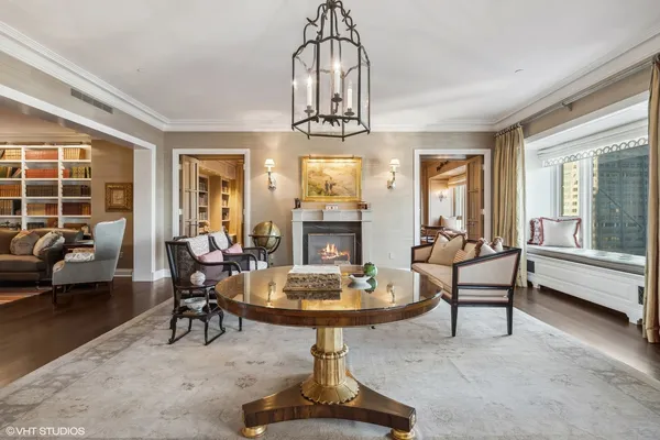 a living room with furniture a fireplace and a chandelier