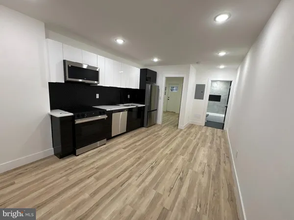 a view of kitchen with wooden floor and electronic appliances
