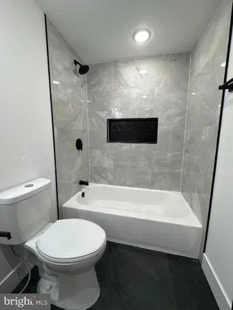 a bathroom with a toilet and a bath tub