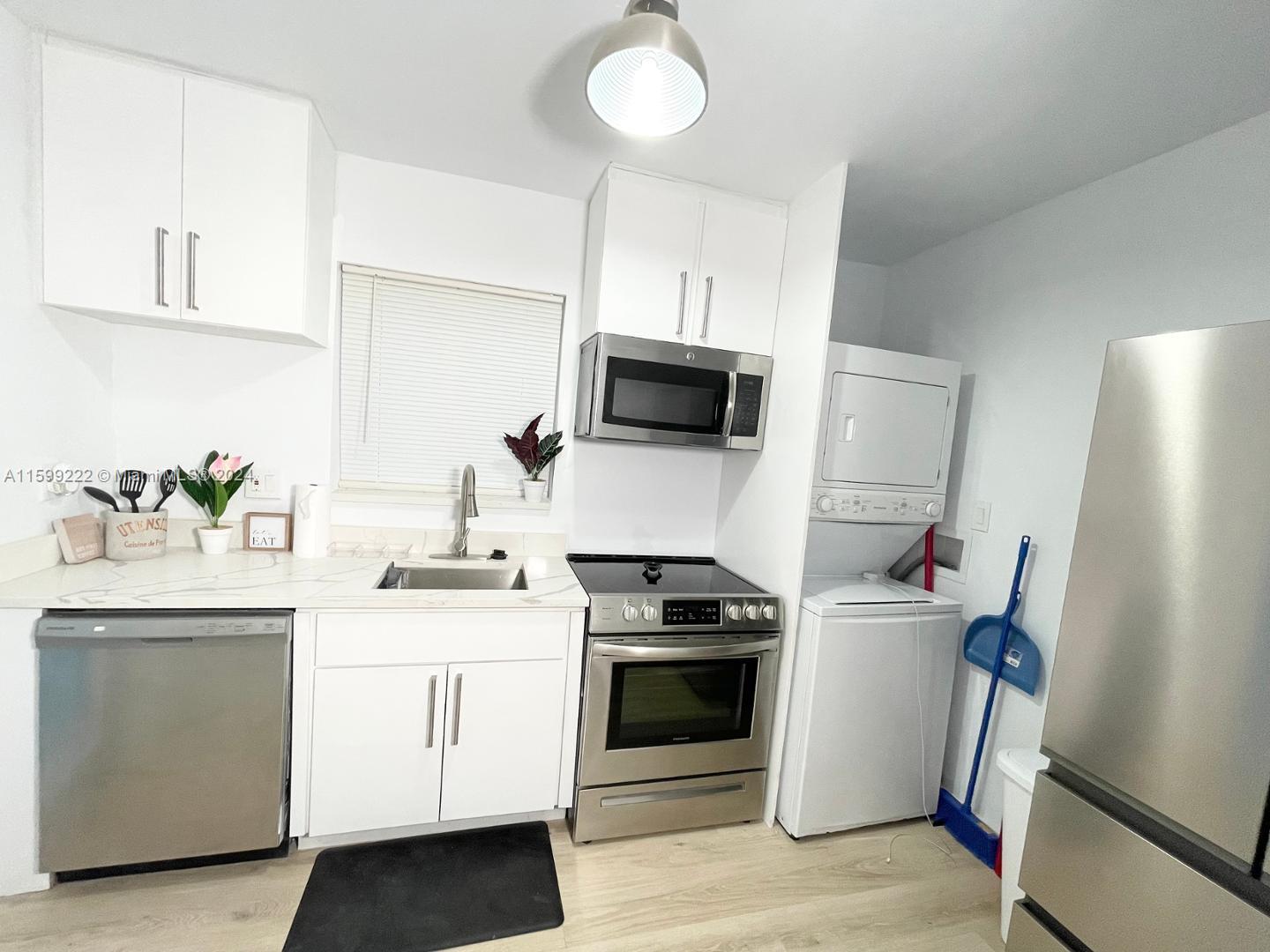 1254 Southwest 13th Street, Unit 1254 Miami, FL 33145 - Photo 10 of 14 a kitchen with stainless steel appliances a white wooden cabinets a stove a sink and a refrigerator