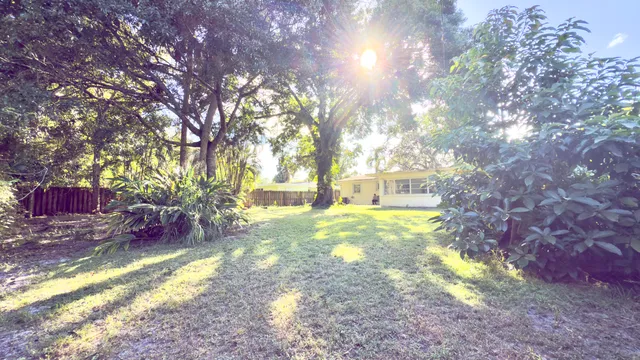 a view of yard with tree and wooden fence