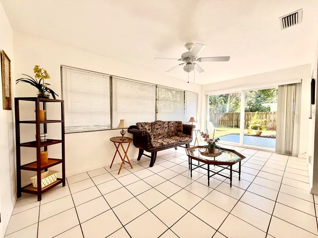 a living room with furniture and a floor to ceiling window