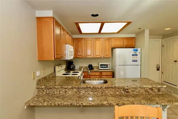 a kitchen with sink refrigerator and large window
