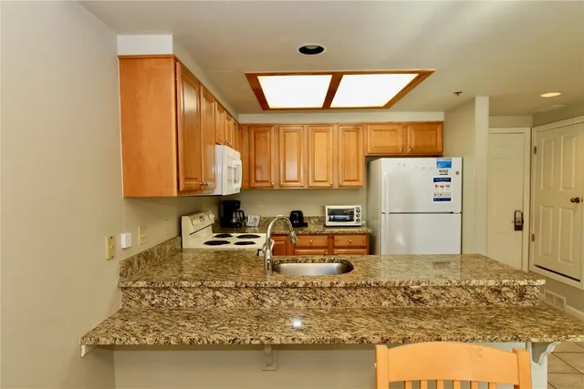 a kitchen with sink refrigerator and large window