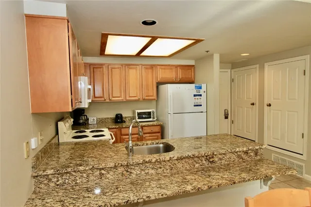 a kitchen with refrigerator cabinets and wooden floor