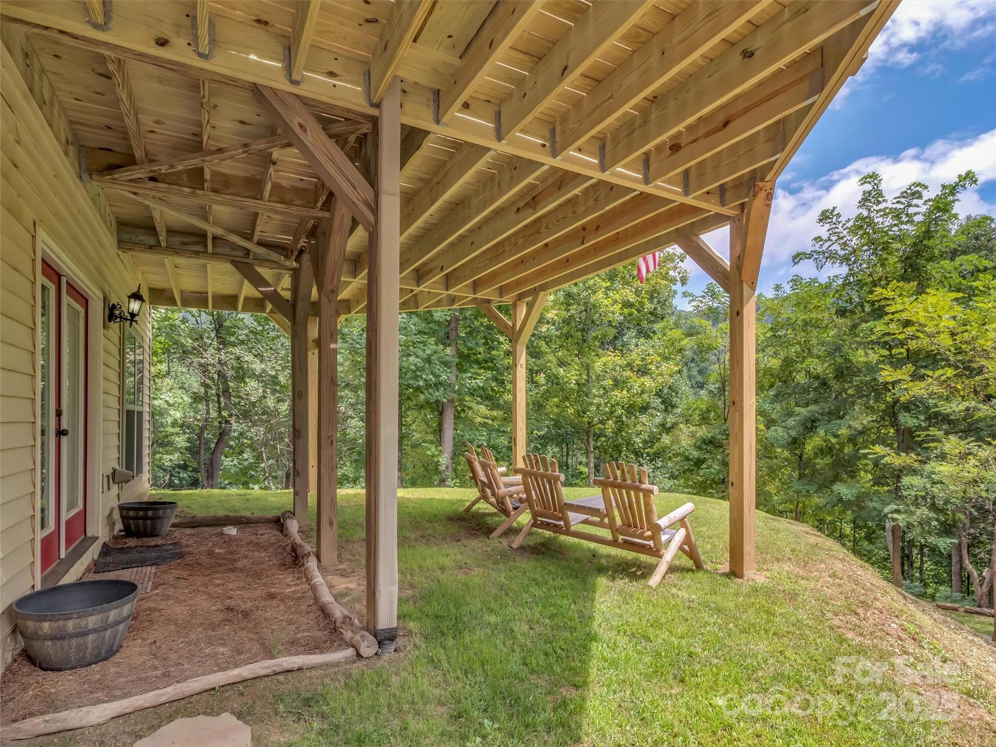4823 Max Patch Road Clyde, NC 28721 - Photo 32 of 47 a view of a patio with table and chairs and floor to ceiling window