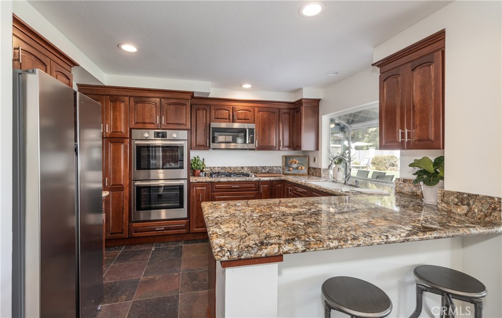 1951 Annapolis Circle Corona, CA 92881 - Photo 12 of 42 a kitchen with stainless steel appliances granite countertop a sink stove and refrigerator