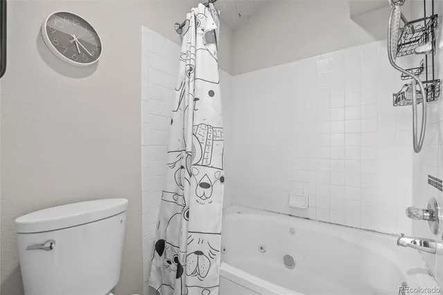 a bathroom with a toilet and a shower curtain