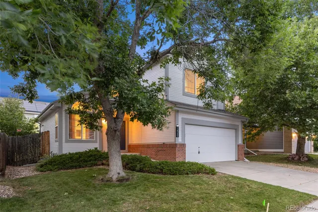 a tree in front of a white house