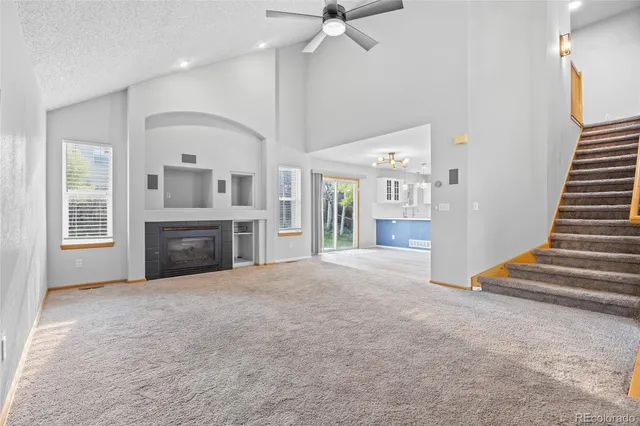 an empty room with windows and fireplace