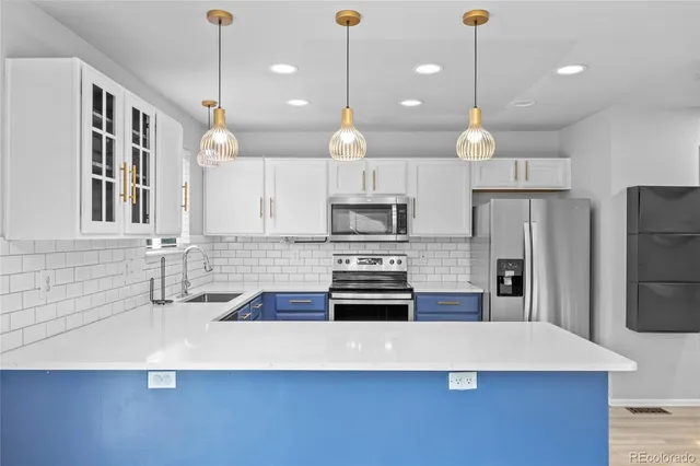 a large kitchen with stainless steel appliances a large counter top oven and cabinets