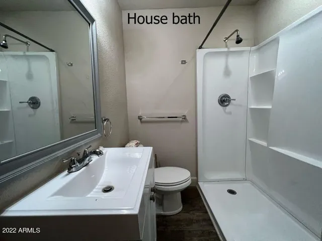 a bathroom with a sink a toilet and shower