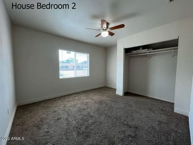 an empty room with windows and fan