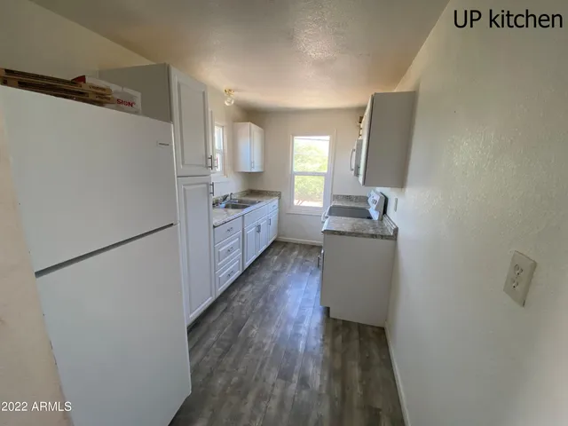 a kitchen with granite countertop a sink stove and cabinets