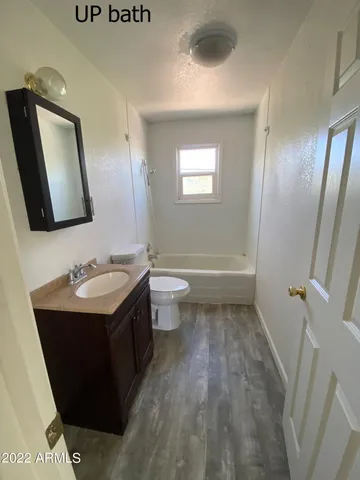 a white toilet sitting next to a bathroom sink and a mirror