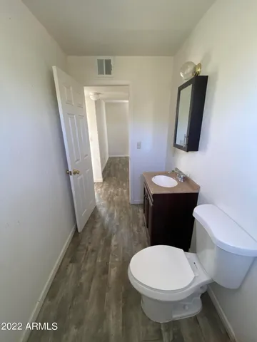 an empty room with wooden floor closet and windows